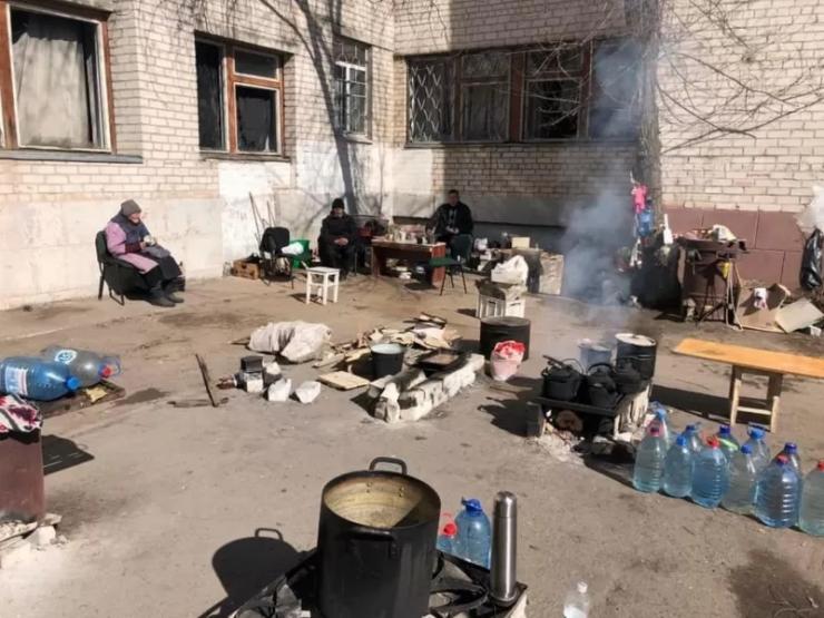 Місцеві мешканці готують їсти у дворі
